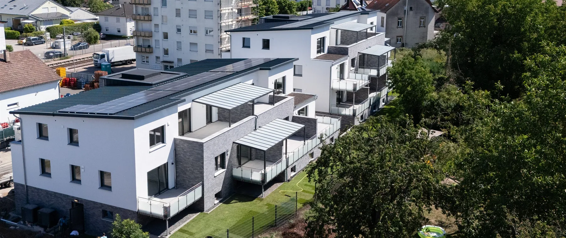 Luftaufnahme des Neubaus in Kraichtal-Unteröwisheim mit Balkonen, Terrassen und Photovoltaik auf den Dächern